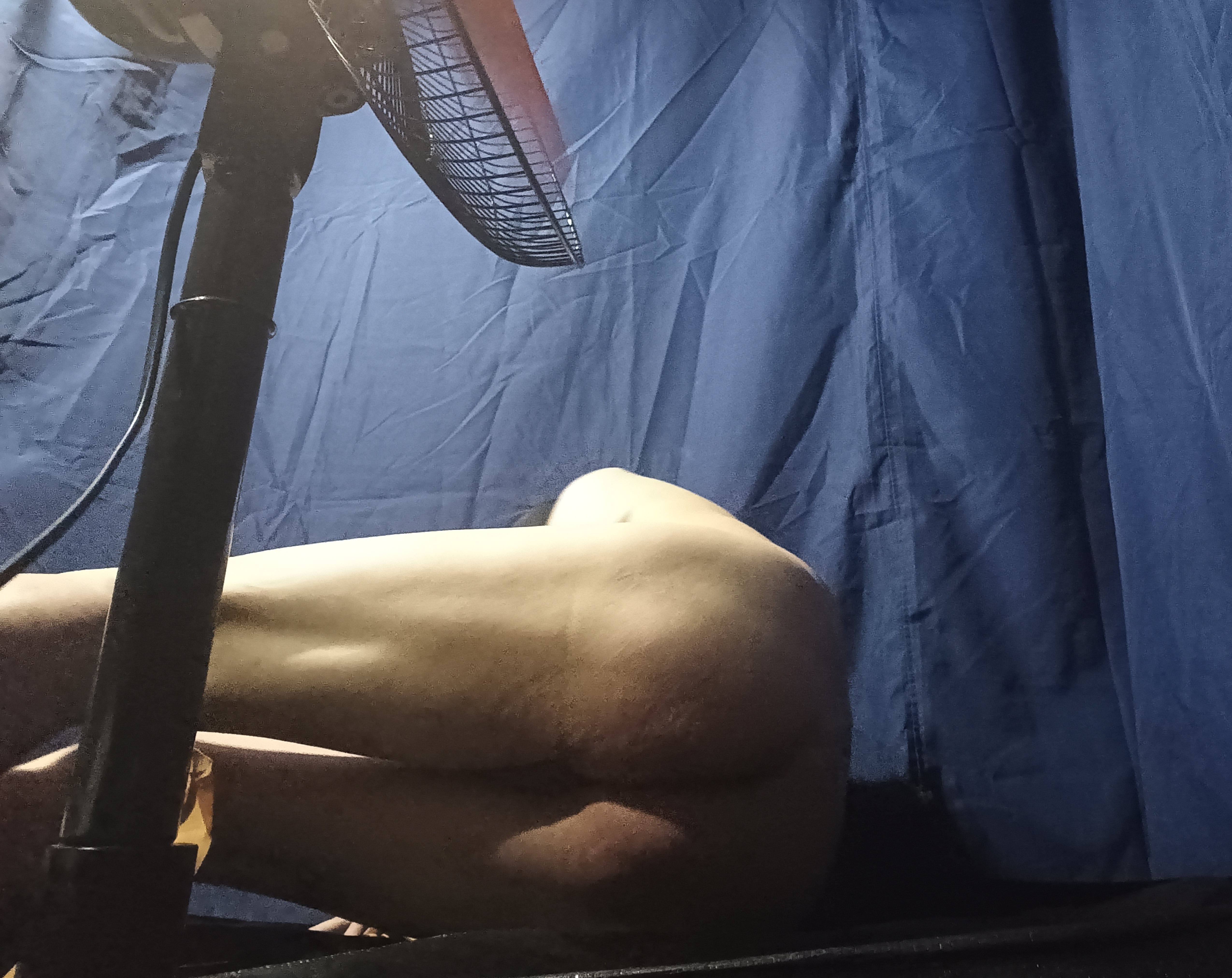 A man being whipped on the butt by a large fan.