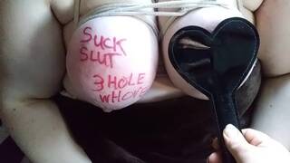 Slave with large breasts humiliated and beat with spiked paddle